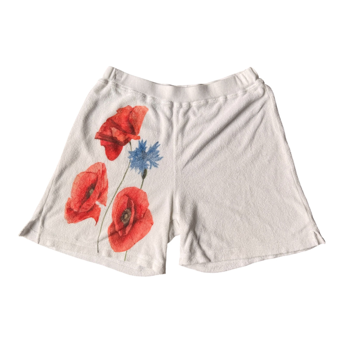 Off-white cotton shorts featuring a printed graphic of red poppies and a blue cornflower on the left leg, displayed against a solid white background.