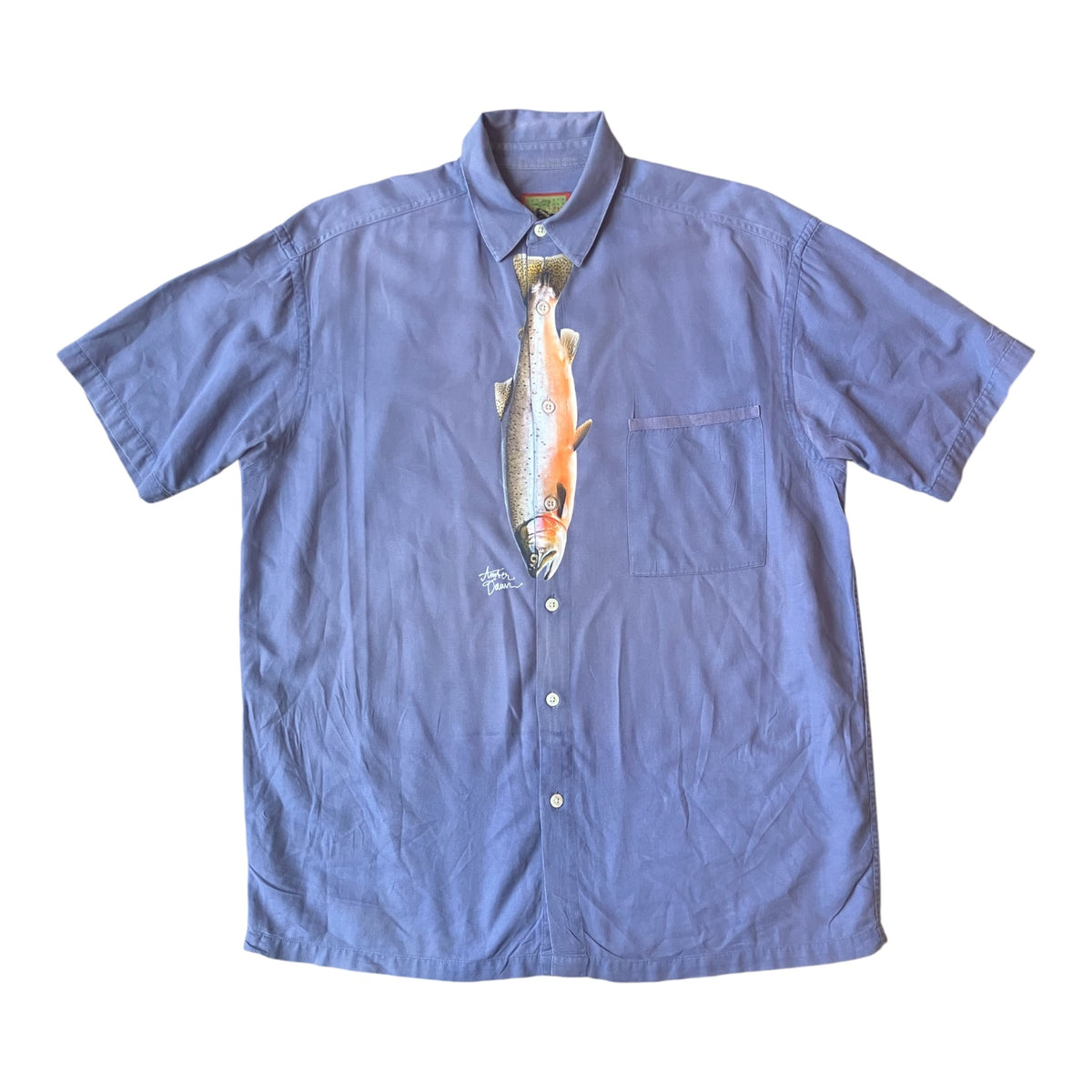A short-sleeve button-up shirt in dusty periwinkle blue, featuring a graphic print of a striped bass fish integrated into the center front panel.