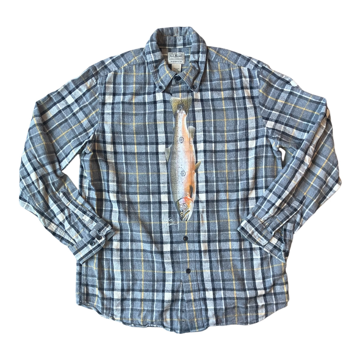 A long-sleeve plaid button-up shirt in blue, gray, and white with thin yellow lines, featuring a graphic print of a fish on the front.