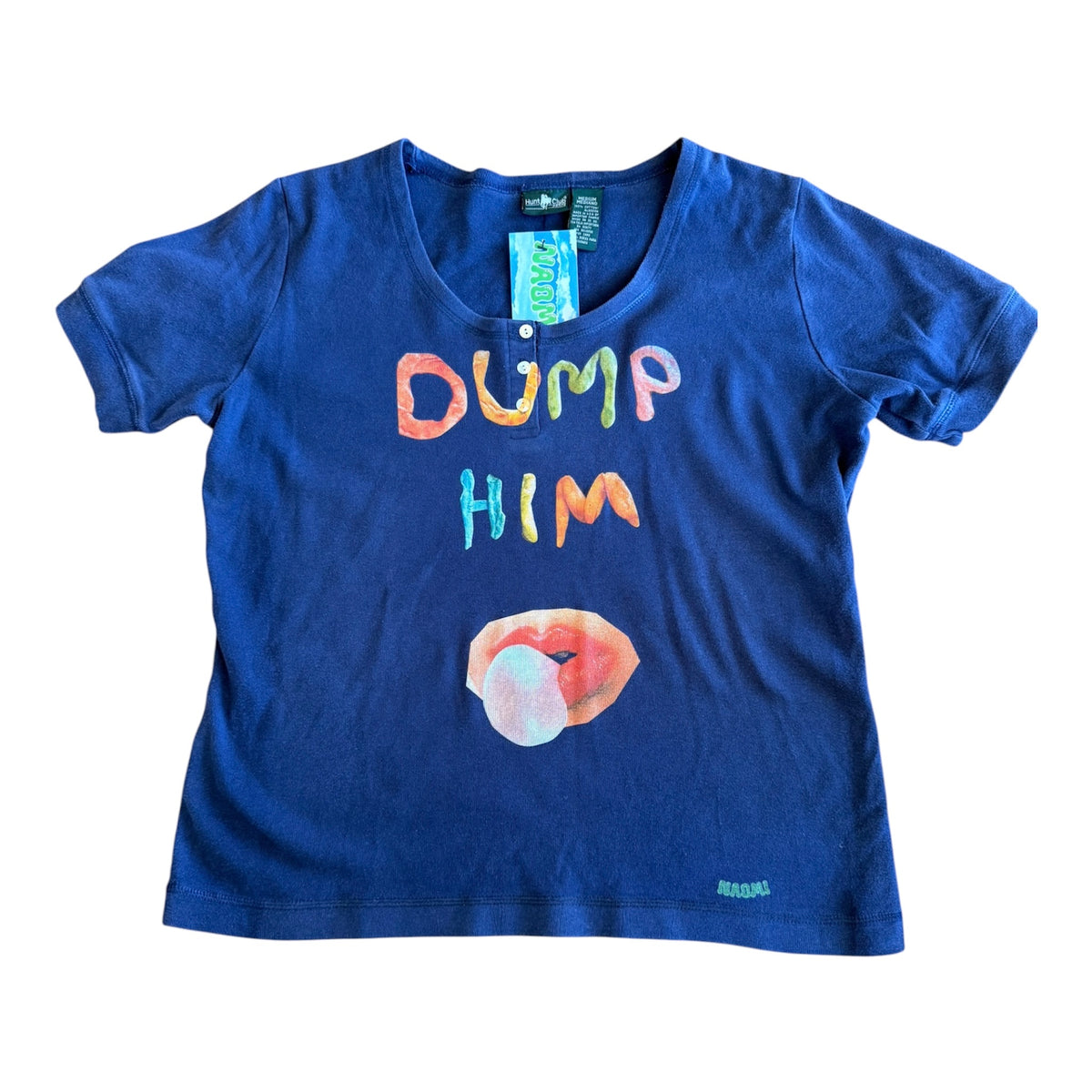 A blue short-sleeve graphic t-shirt featuring the text 'DUMP HIM' in multicolored letters above a graphic of lips with a bubblegum bubble. The shirt is laid flat on a white background