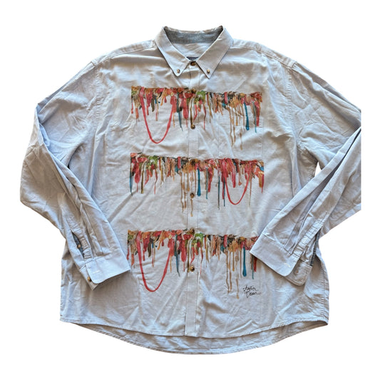 A light gray long-sleeve button-down shirt featuring three horizontal rows of colorful dripping gum patterns across the front, laid flat on a white background.