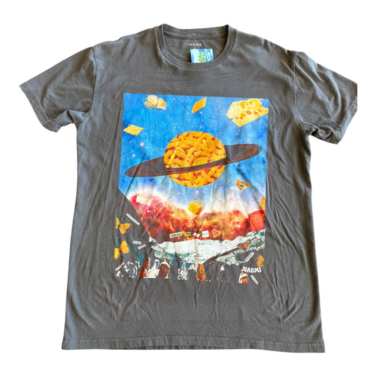 A dark gray crewneck t-shirt featuring a large, colorful graphic print on the front. The graphic depicts a cosmic scene with a ringed planet, floating cheese wedges, and a dog crowd under a blue starry sky.