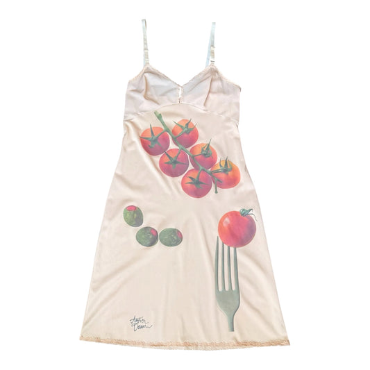 A cream-colored spaghetti strap nightgown featuring a graphic print of red tomatoes, green olives, and a fork with a tomato on it, shown against a plain white background.