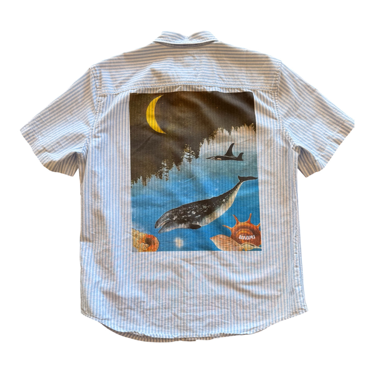 A short-sleeve button-up shirt with a light blue and white stripe pattern, featuring a large rectangular graphic print on the back depicting a whale, an orca, a crescent moon, and sea life.