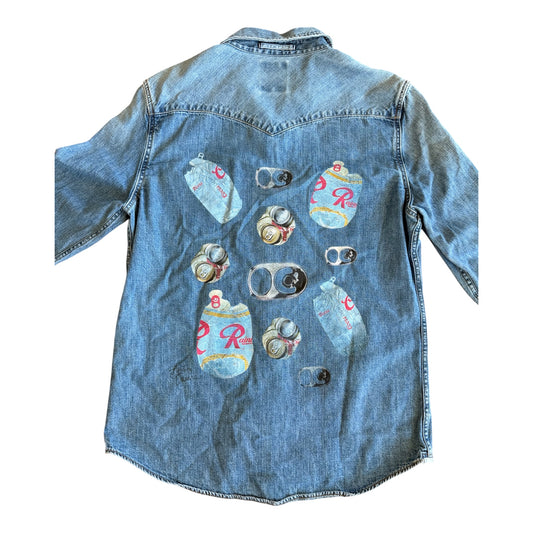 A light blue denim shirt shown from the back, featuring a graphic print of multiple vintage-style beer cans with the iconic red 'R' logo.