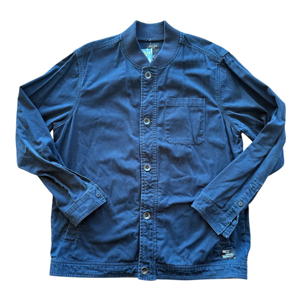 A blue long-sleeve button-up shirt jacket with a mandarin collar, laid flat on a white background.