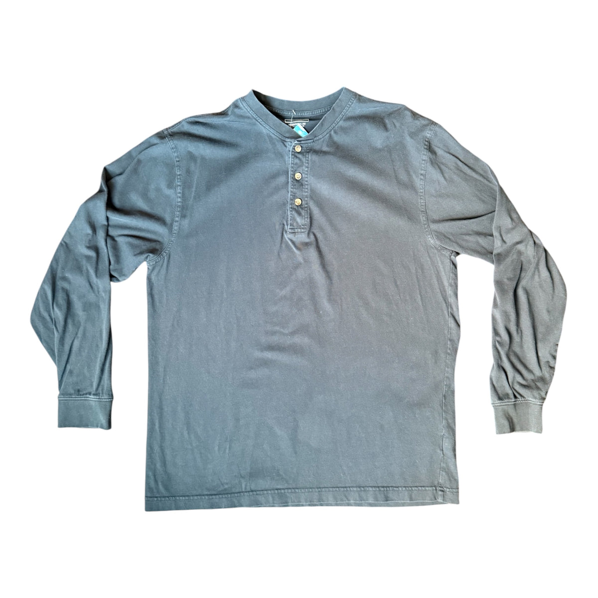 A long-sleeve henley shirt in a muted slate blue-gray color, featuring a three-button placket and ribbed cuffs, laid flat against a white background.