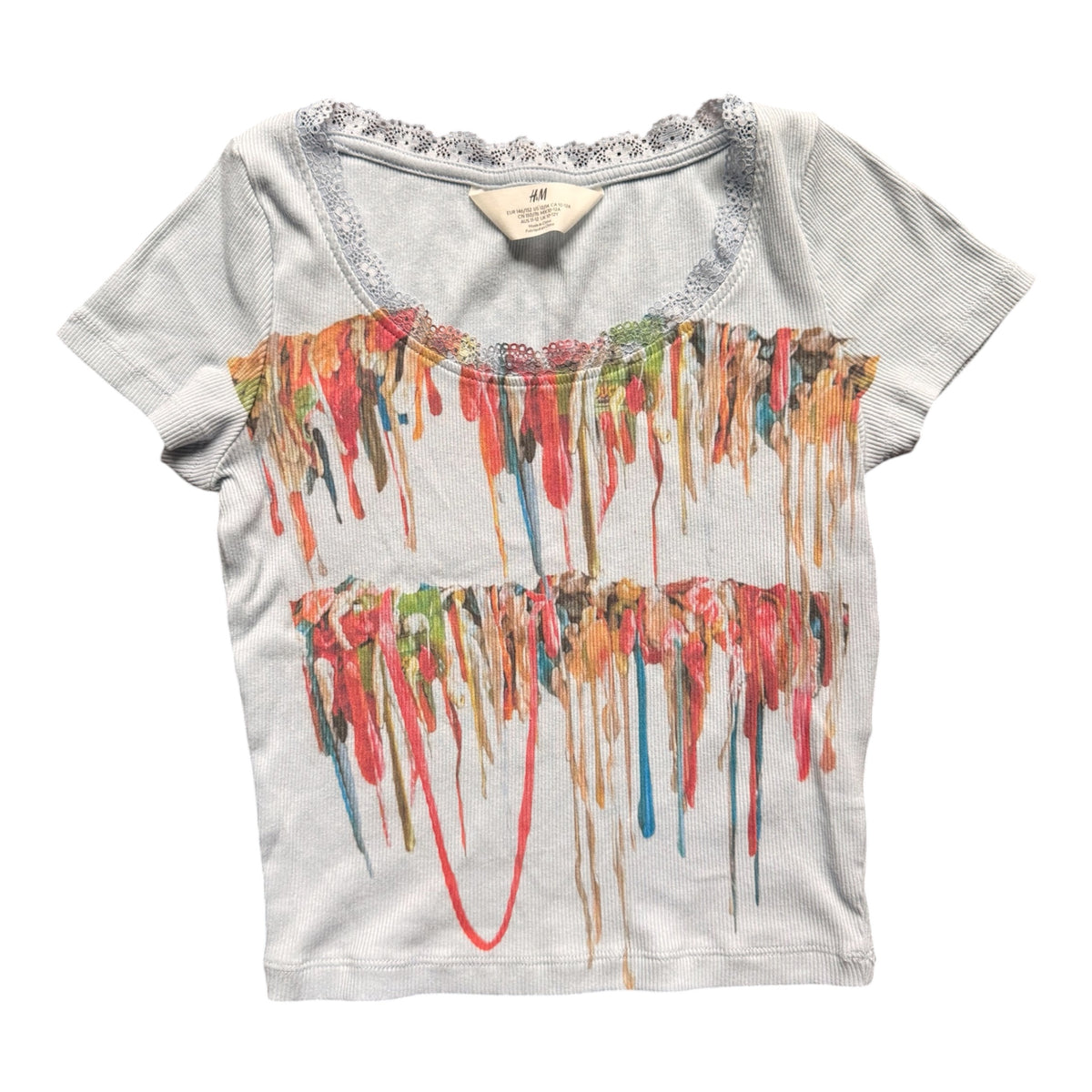 A light gray short-sleeve crop top with a scoop neckline trimmed in silver glitter, featuring a colorful dripping gum graphic across the front.