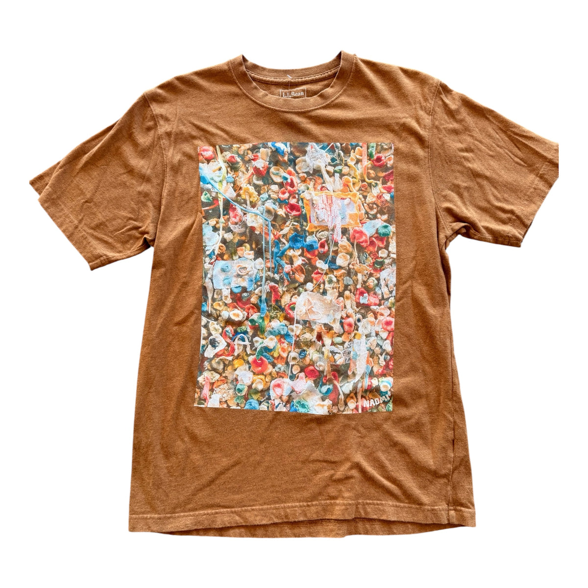 A brown short-sleeve t-shirt with a large rectangular graphic print on the front of the gum wall