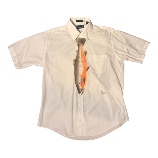 A short-sleeve button-up shirt in a light cream or off-white color, featuring a realistic printed fish graphic on the front chest. The shirt is laid flat against a solid white background.