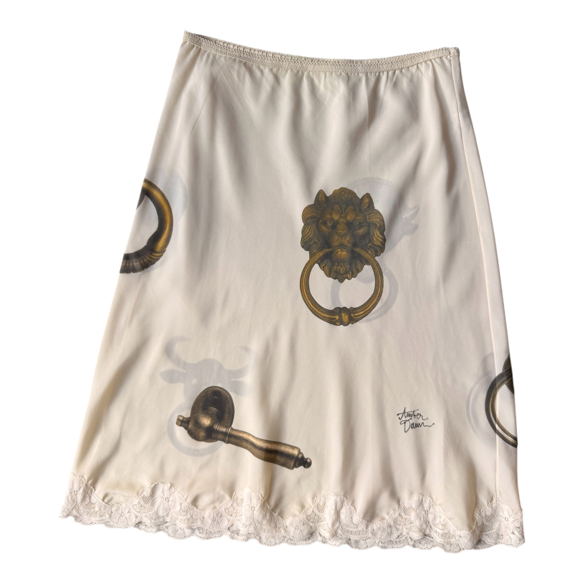 An A-line skirt in cream-colored silk with a print of antique brass door knobs and a lace hem.
