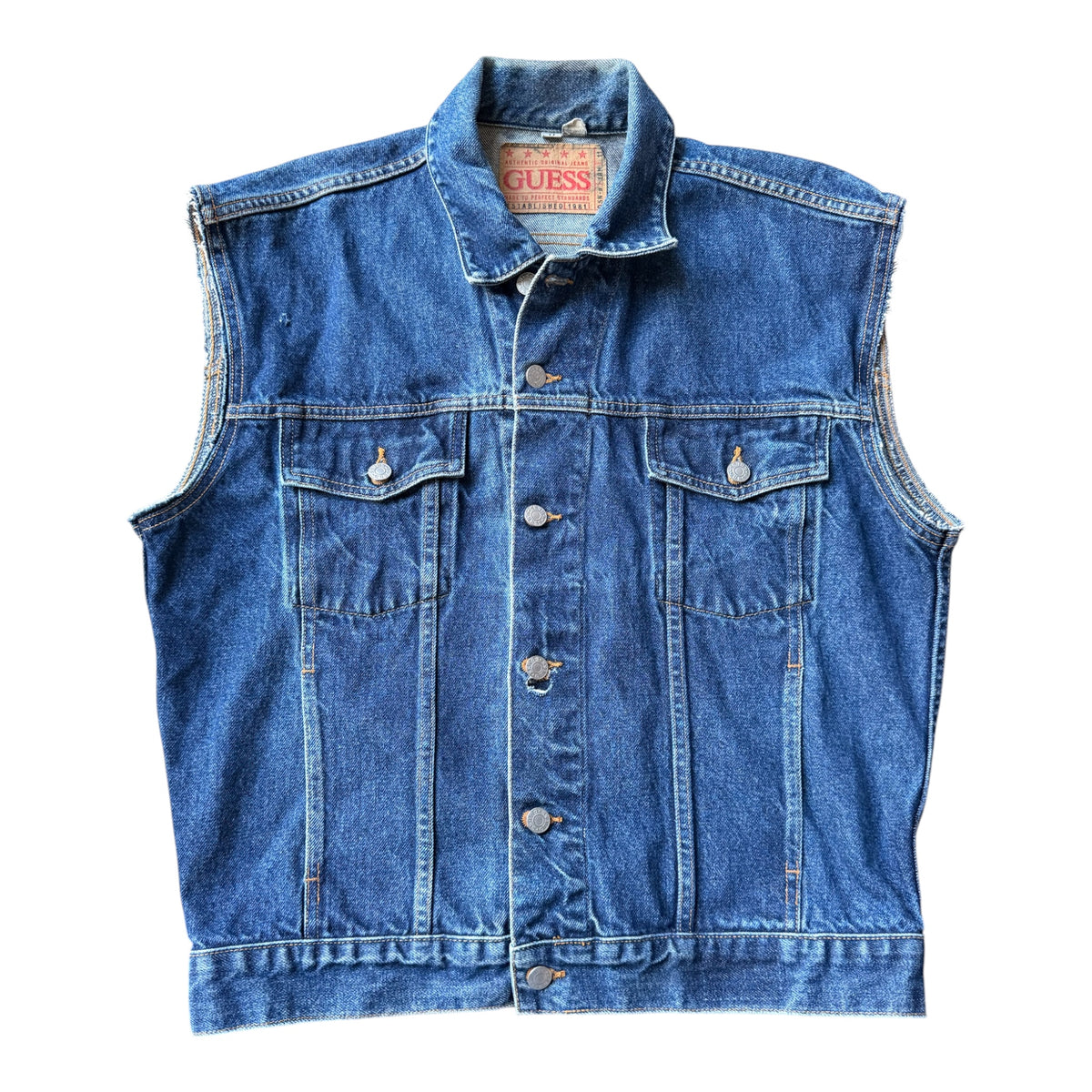 A blue denim vest from Guess, featuring a button-up front, two chest flap pockets, and a classic collar, laid flat against a white background.