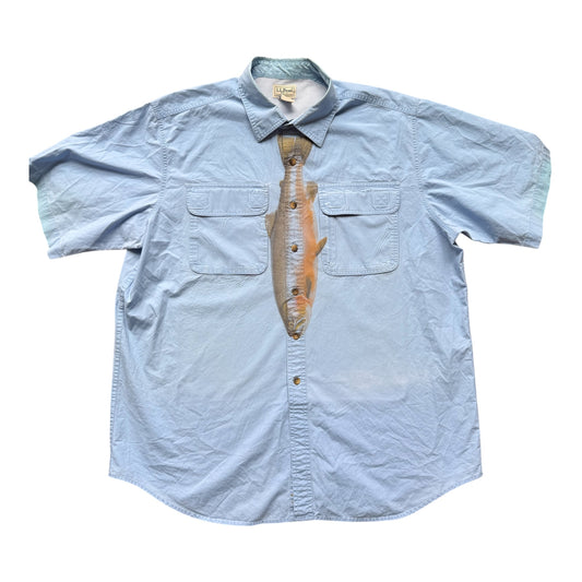 A light blue short-sleeve button-up shirt with a printed realistic fish graphic on the front, styled like a necktie, against a plain white background.