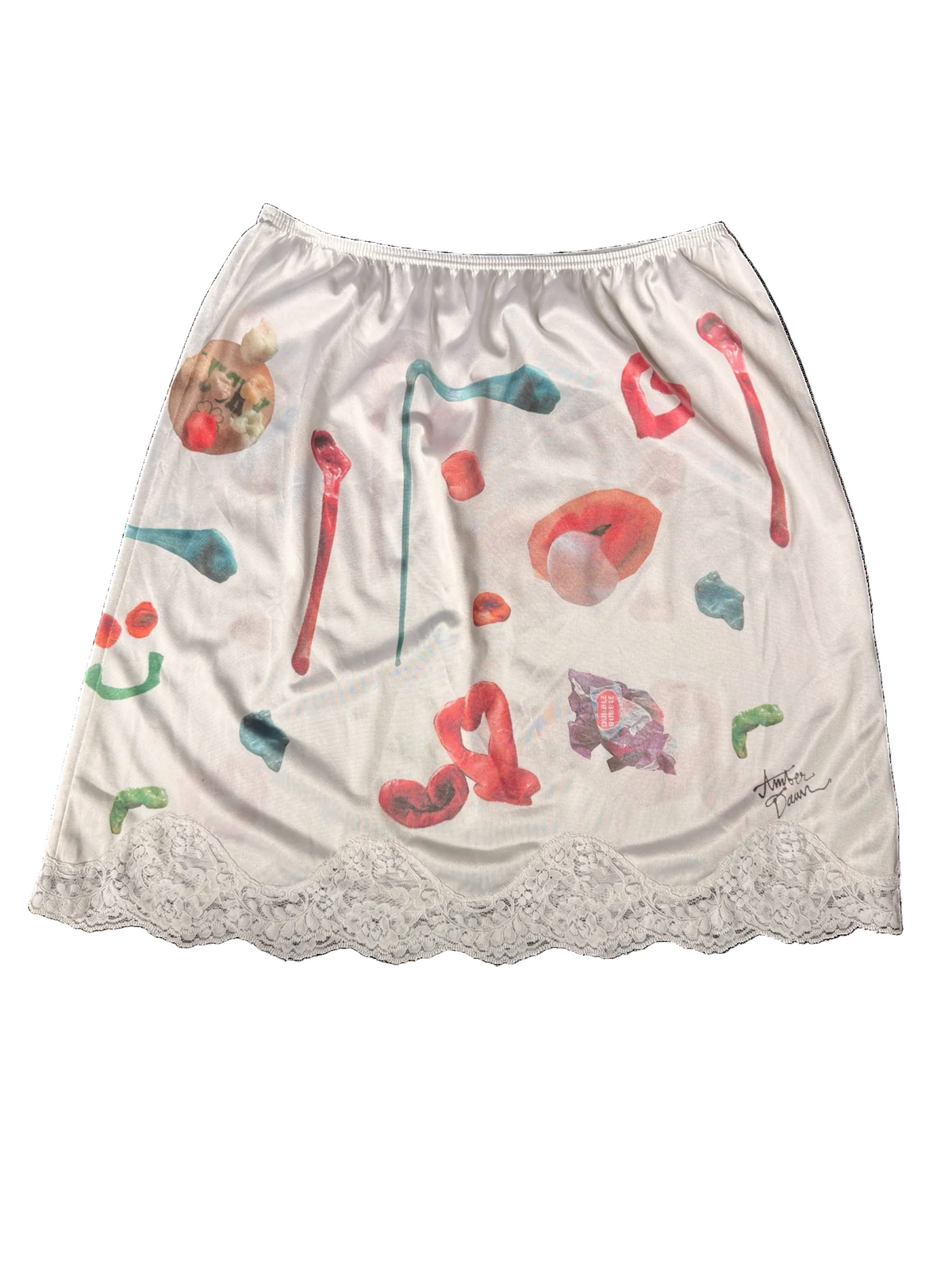 An off-white satin mini skirt featuring a surreal collage print of colorful abstract gum shapes and a white lace hem.
