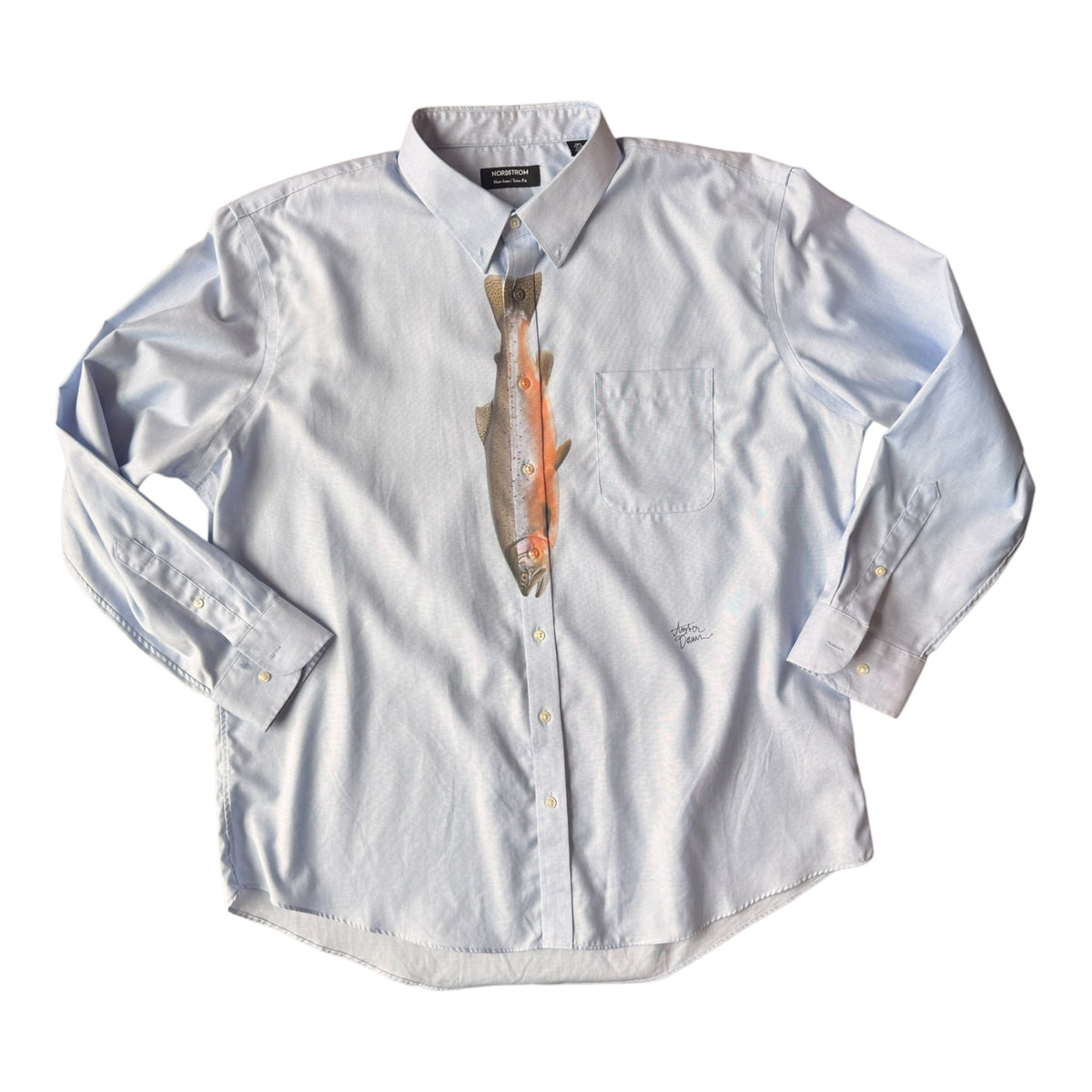 A light blue long-sleeve button-down shirt with a printed fish graphic on the front, styled as if wearing a tie, on a plain white background.