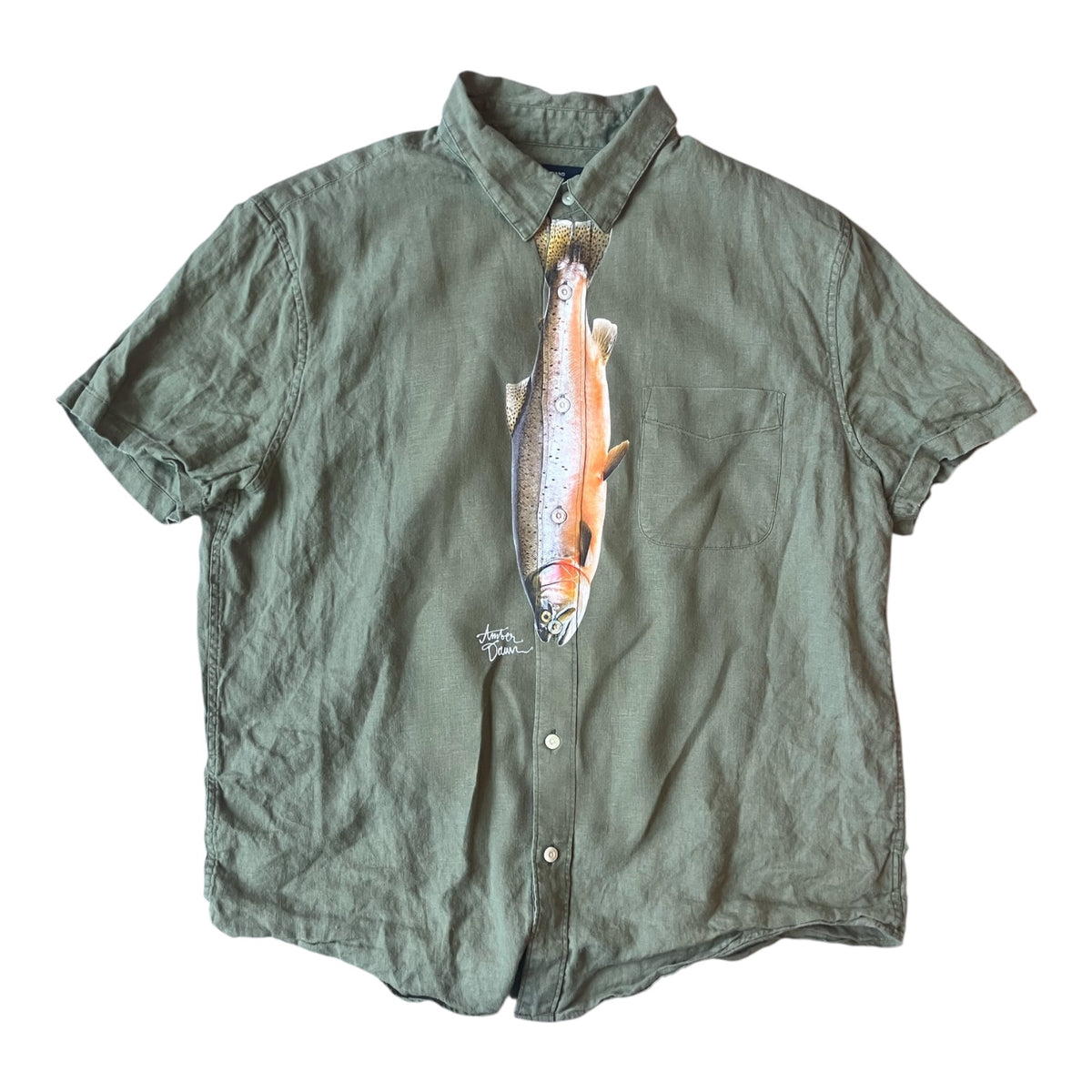 An olive green short-sleeve button-up shirt with a large printed trout graphic on the front, laid flat against a white background.