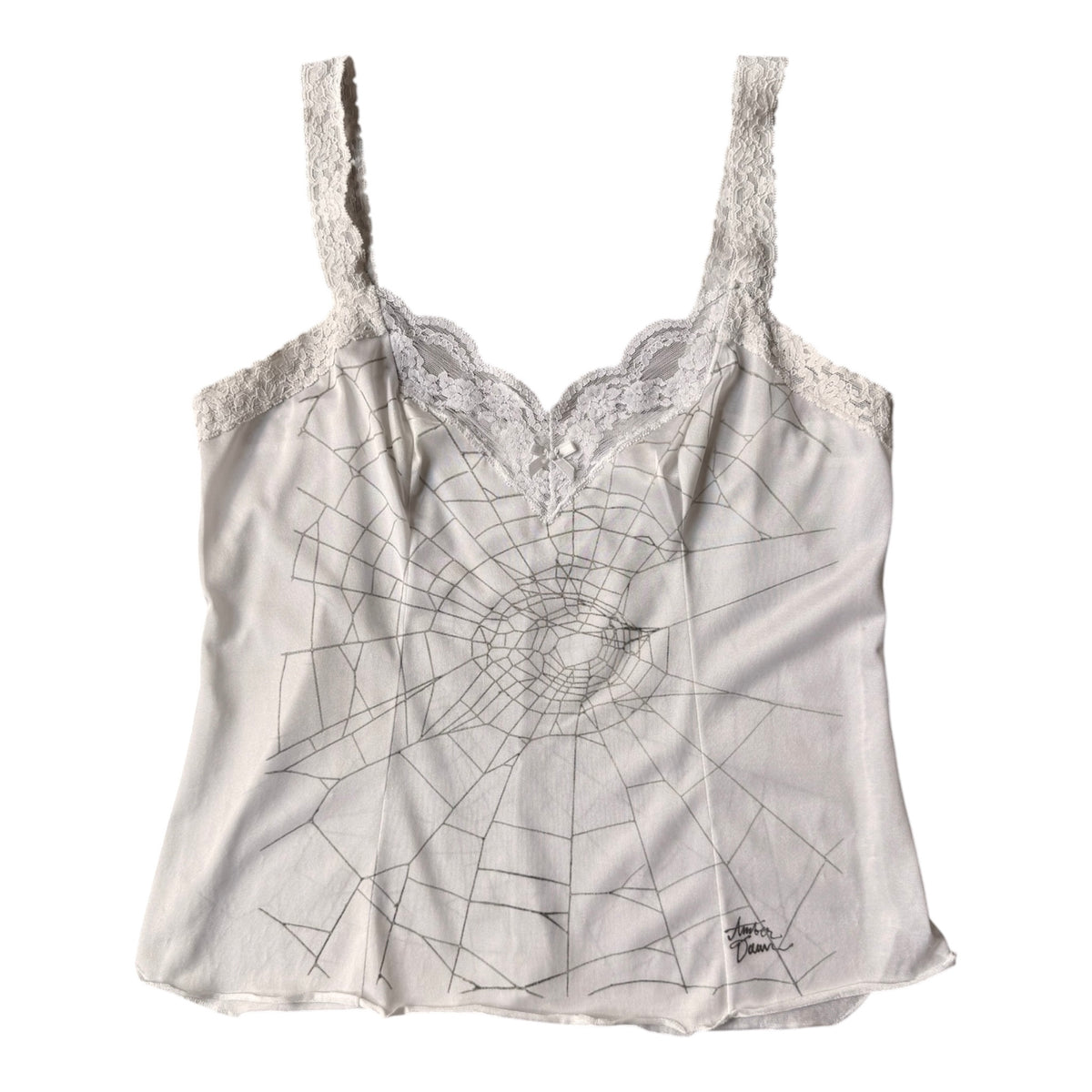 A white camisole top with a spiderweb line print on the front, featuring lace trim along the neckline and straps.